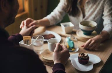 the dater hold hands while enjoying a meal