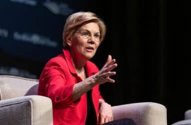 Elizabeth Warren on stage on a couch