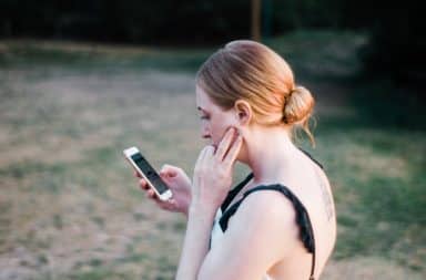 Pensive woman texting on her phone