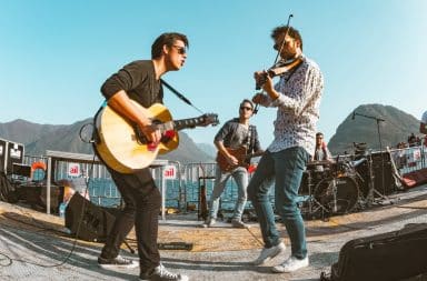 Three musicians playing in a band outside