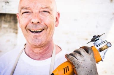 Dad holding a power saw and smiling