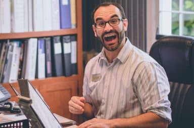 Male psychologist smiling at his desk