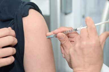 Needle into arm for vaccine administration