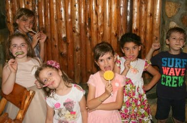 Kids eating lollipops at a party