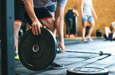 Man putting weight on a barbell