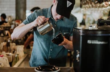 Barista pouring coffee into a cup