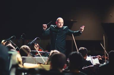 Conductor maestro on stage performing a symphony orchestra song