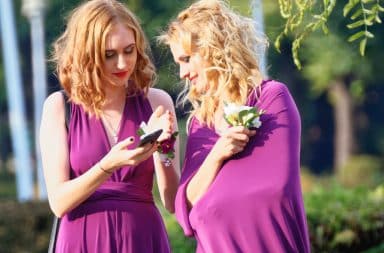 Two bridesmaids looking at a cell phone