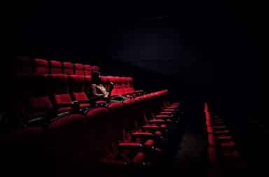 Woman sitting alone in a movie theater