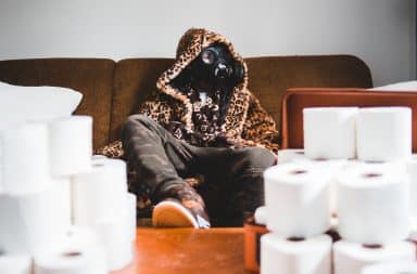 Human wearing gas mask sitting on the sofa