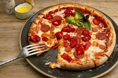 Pizza with garnish and a fork