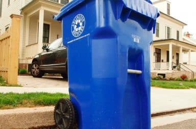 Recyling bin outside a house on the curb of street