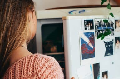 Woman opening the freezer of a refrigerator