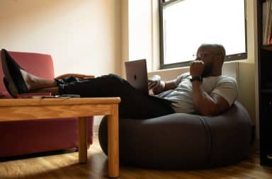 Man on laptop sitting on a bean bag chair