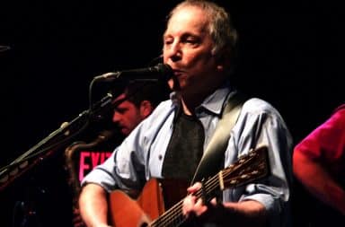 Paul Simon on stage playing guitar