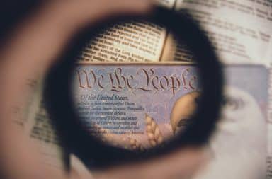 We the People on a passport with magnifying glass