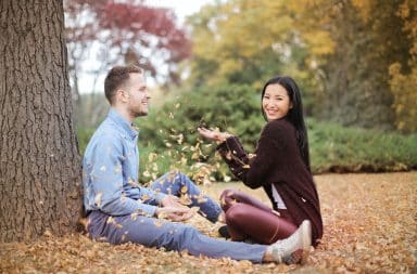 Couple outside woman throwing leaves at boyfriend