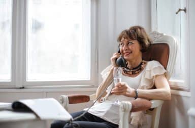 Woman on the phone at home drinking wine