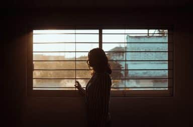 Woman in the window blinds