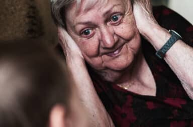 Grandmother covering her ears when grandson talks