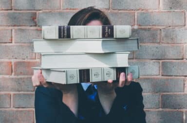 Holding up school textbooks in front of face