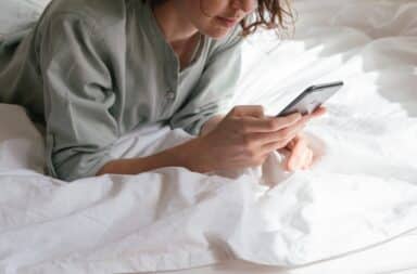 Woman checking her phone in bed