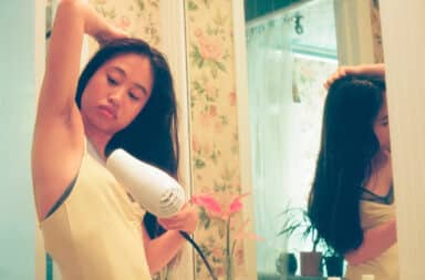 Woman blow drying underarm hair