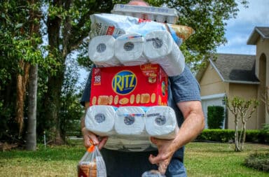 Grocery items stacked in hands of man