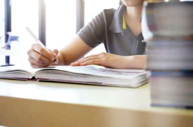 Person writing in a textbook