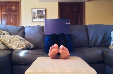 Work at home with feet up on the sofa footrest