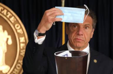 Cuomo puts a mask in a trash can