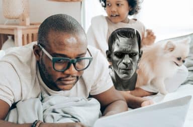 Dad, child, Frankenstein, and laptop on the bed