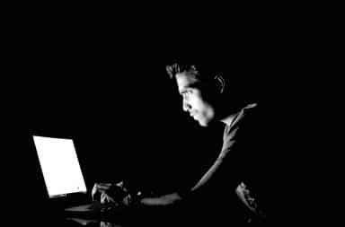 guy using a laptop in the dark