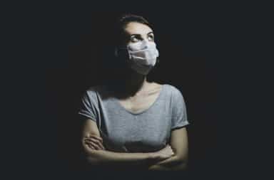Woman wearing a face mask pondering