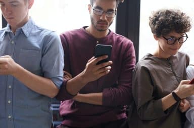 Three people texting on their phones