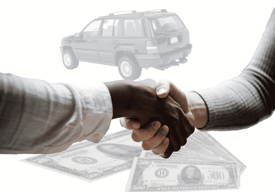 Shaking hands in front of a car and cash