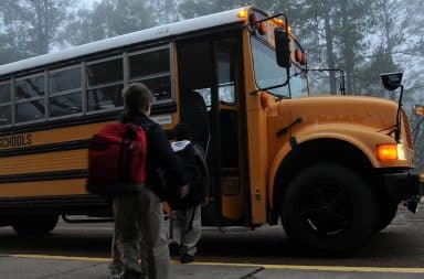 kid getting onto the school bus