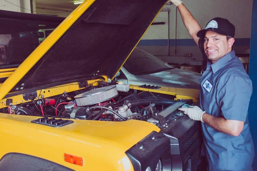 Engine mechanic with hood of car open