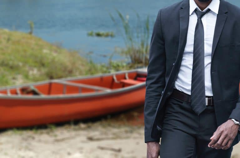 wearing a suit by the river canoe