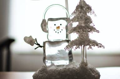 Snowman made of ice waving from inside