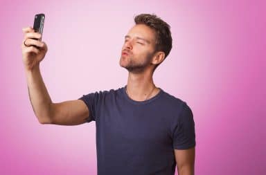 Man taking selfie with pink background