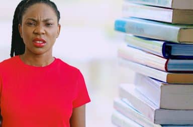 a disgusted woman next to a stack of books