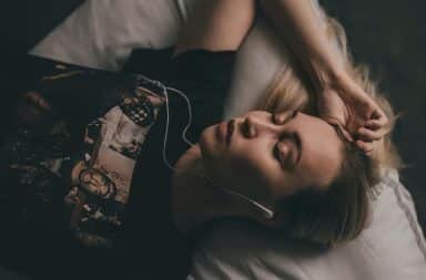 woman listening to something in bed