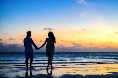 Lovers holding hands on beach