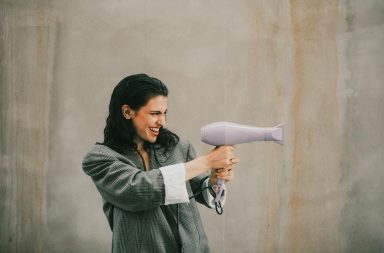 Woman holding hair dryer funny
