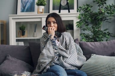 woman watching TV scared