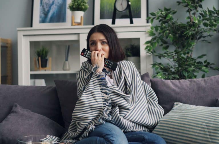 woman watching TV scared