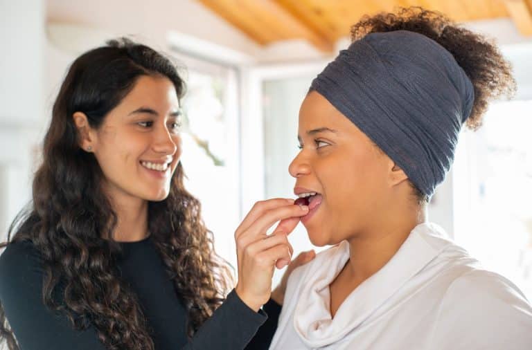 women feeding each other fruit