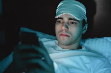 man in bed in eye mask