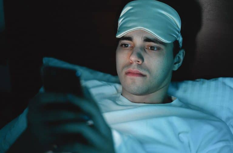 man in bed in eye mask